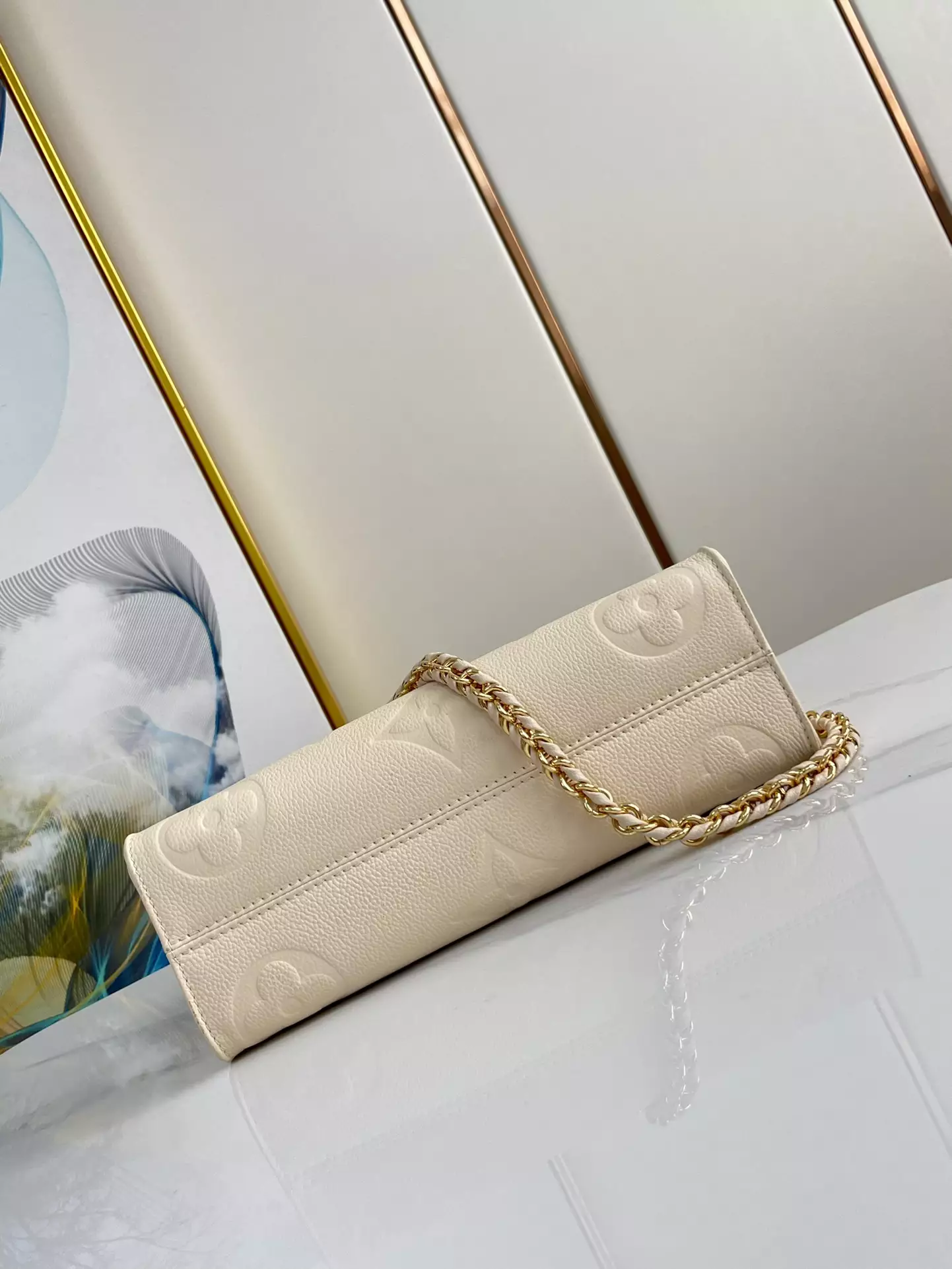 OnTheGo East West Monogram Empreinte Creme Leather