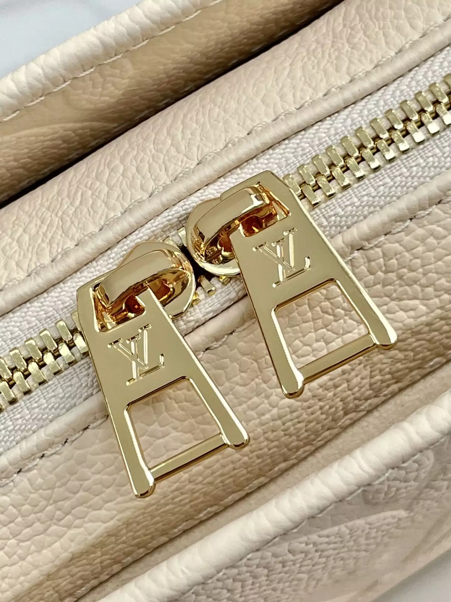 OnTheGo East West Monogram Empreinte Creme Leather