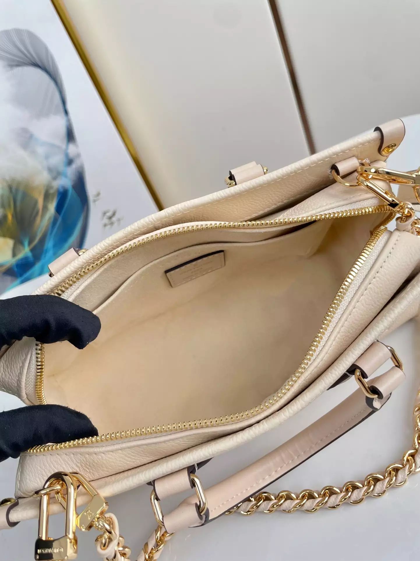 OnTheGo East West Monogram Empreinte Creme Leather